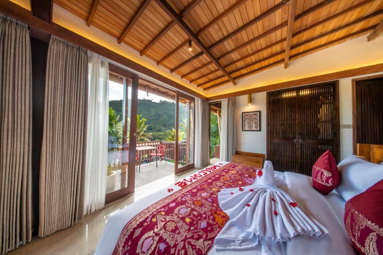 a bedroom with a bed and a large window at Kropak Sidemen in Sidemen
