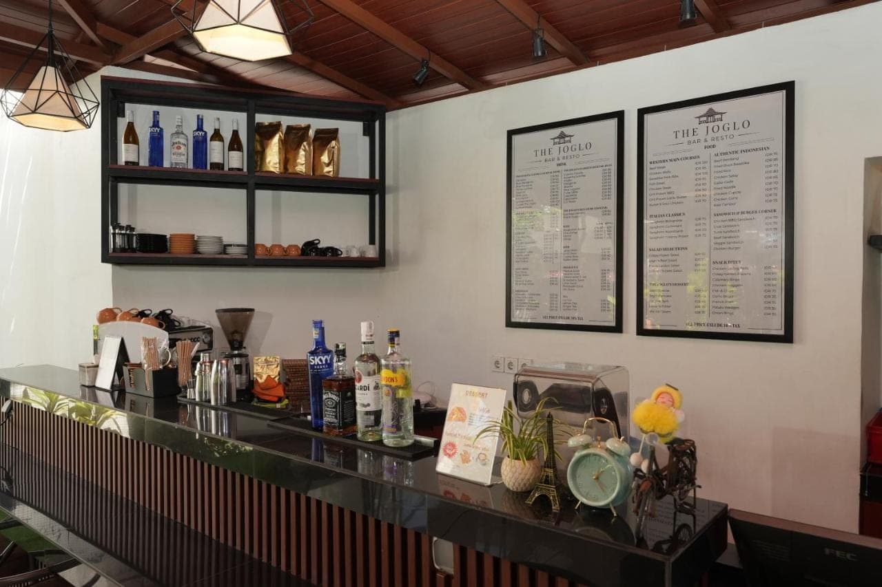 a bar in a restaurant with a counter with drinks at Swastika Bungalows in Sanur
