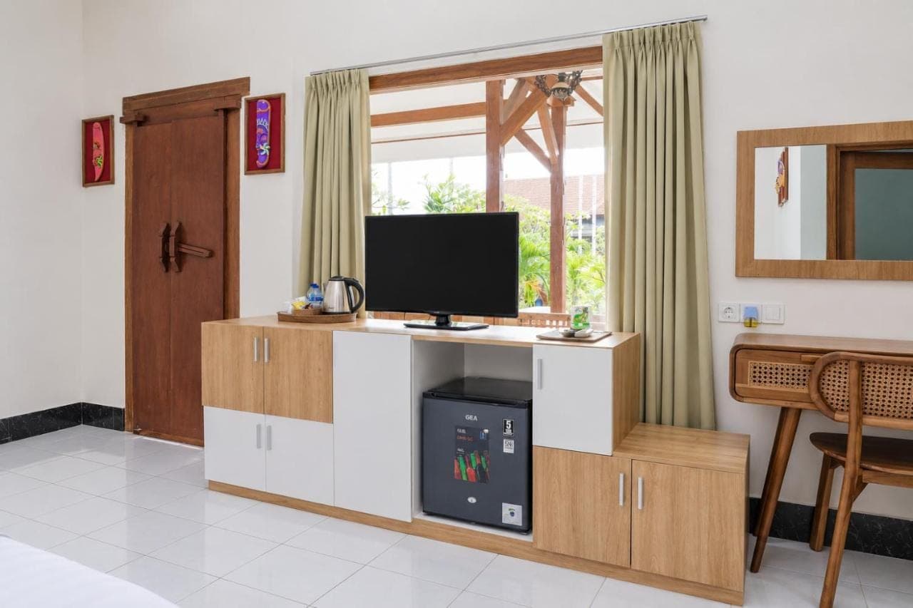 a living room with a desk with a tv on it at Swastika Bungalows in Sanur