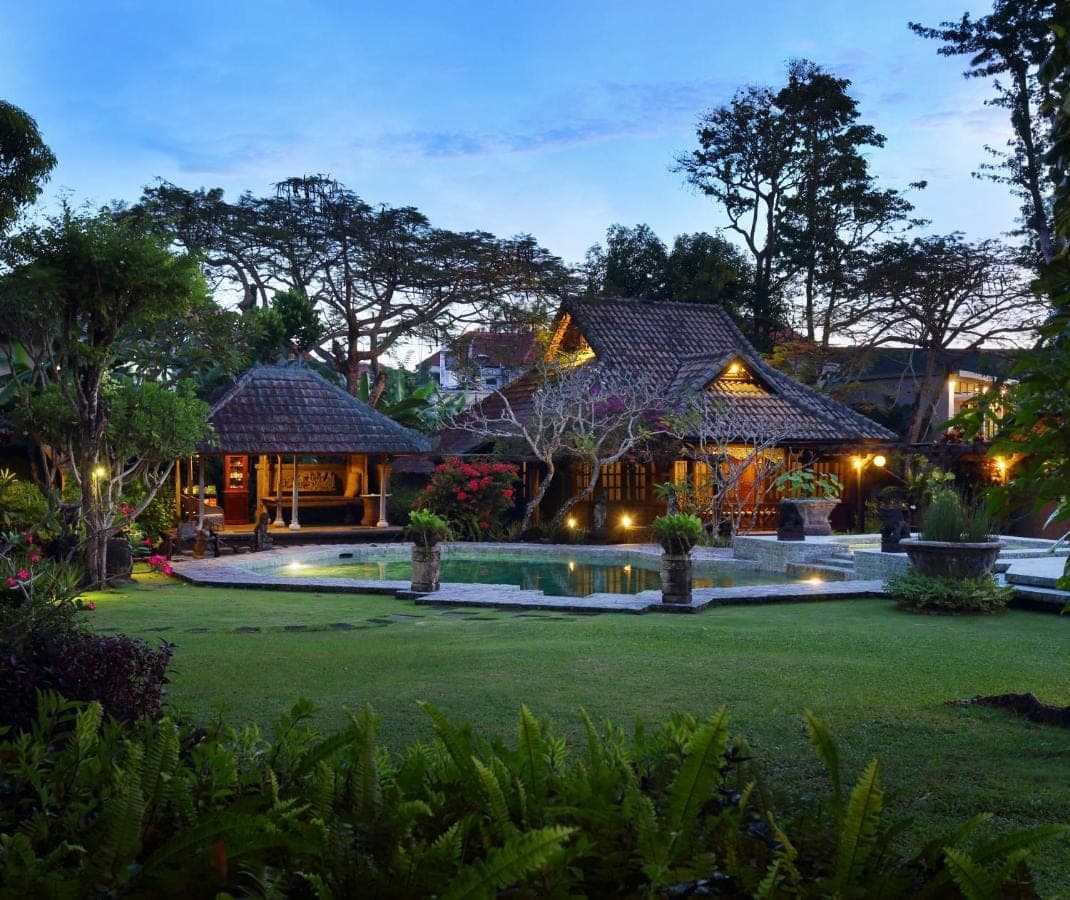 a house with a swimming pool in front of a yard at Alindra Villas &amp; Spa in Nusa Dua