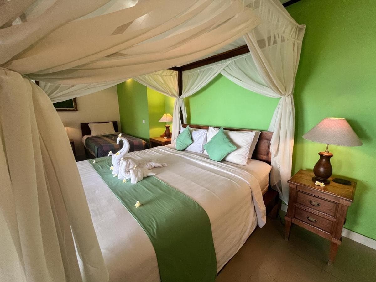 a bedroom with a large bed with a canopy at Apa Kabar Villas in Amed