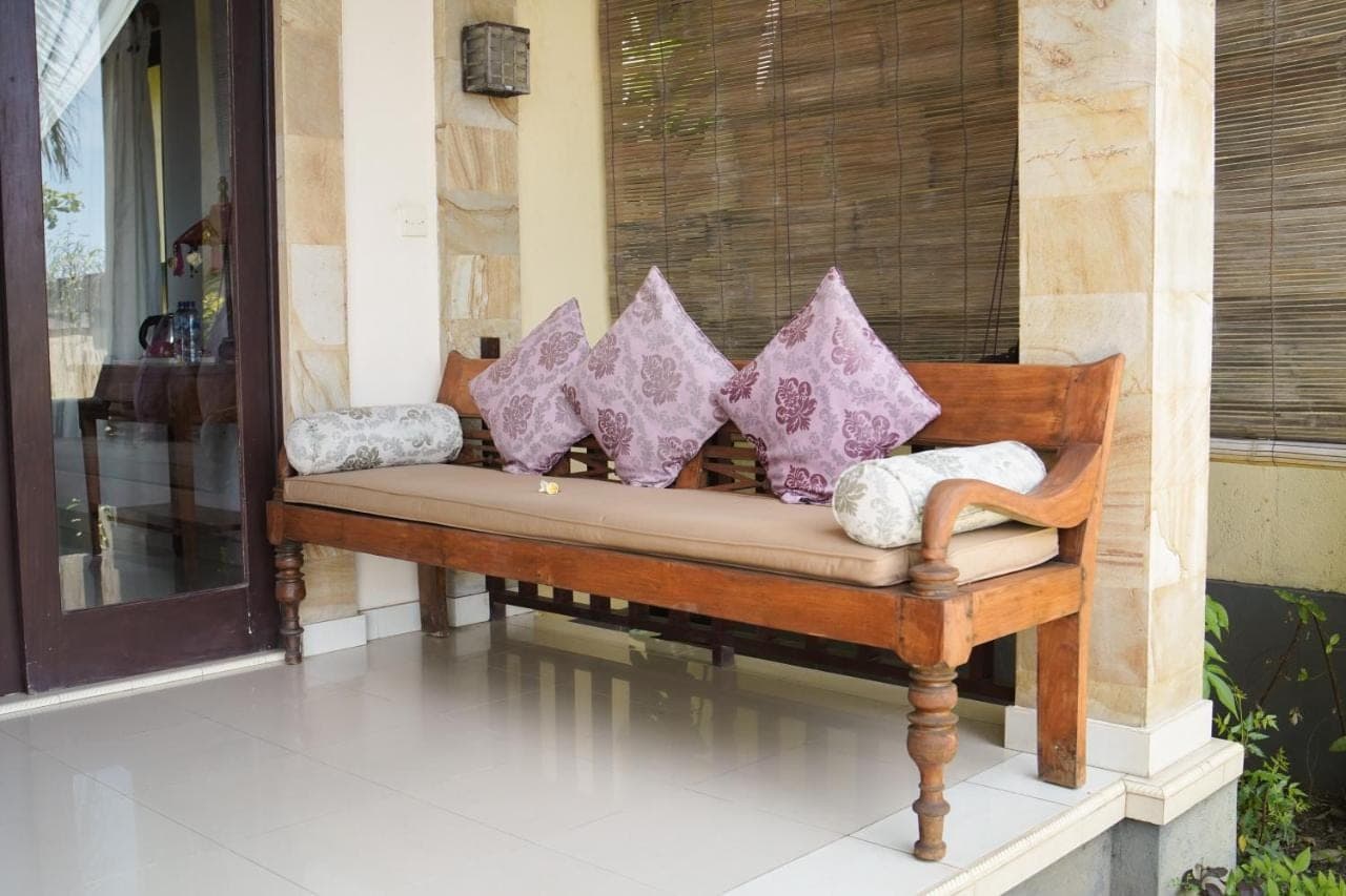 a bench with four pillows on it on a porch at Apa Kabar Villas in Amed