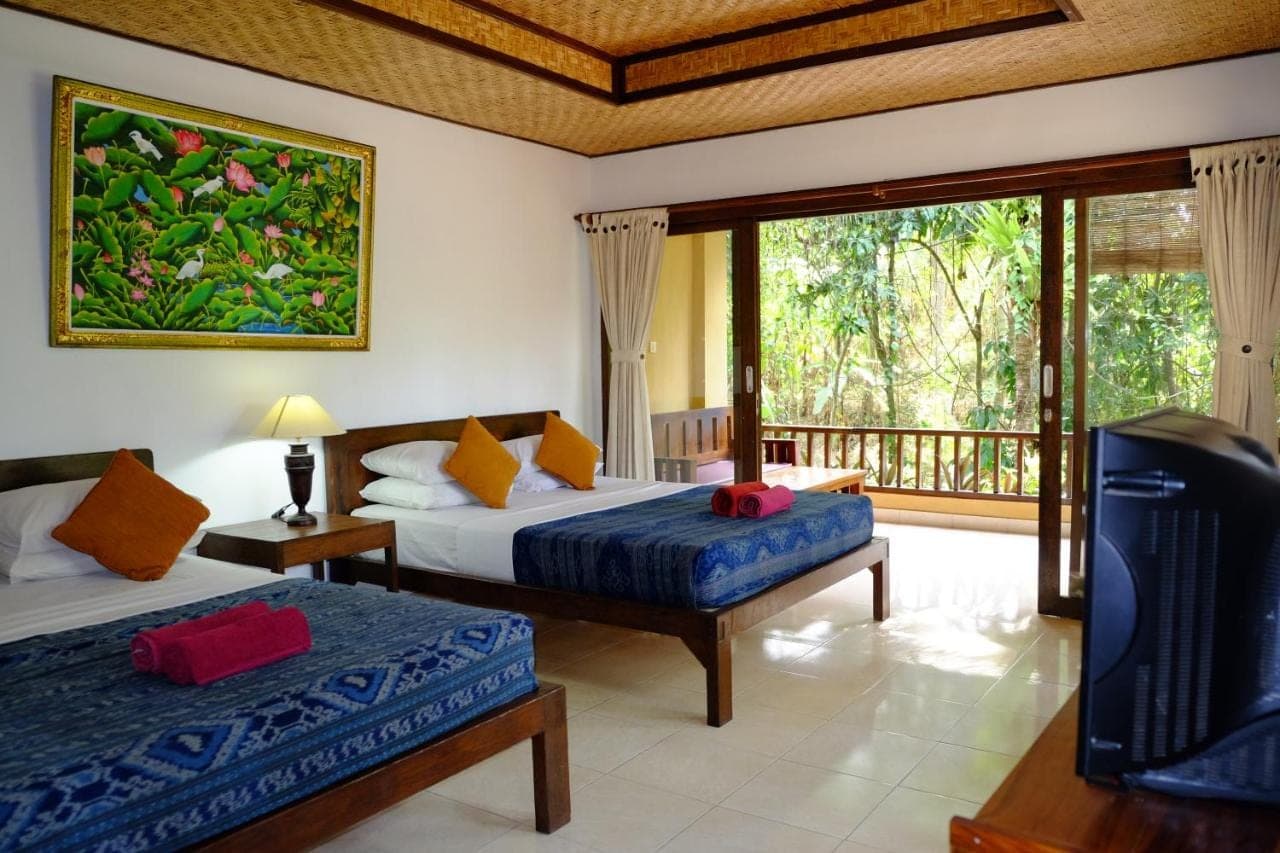a bedroom with two beds and a balcony at Jati 3 Bungalows in Ubud