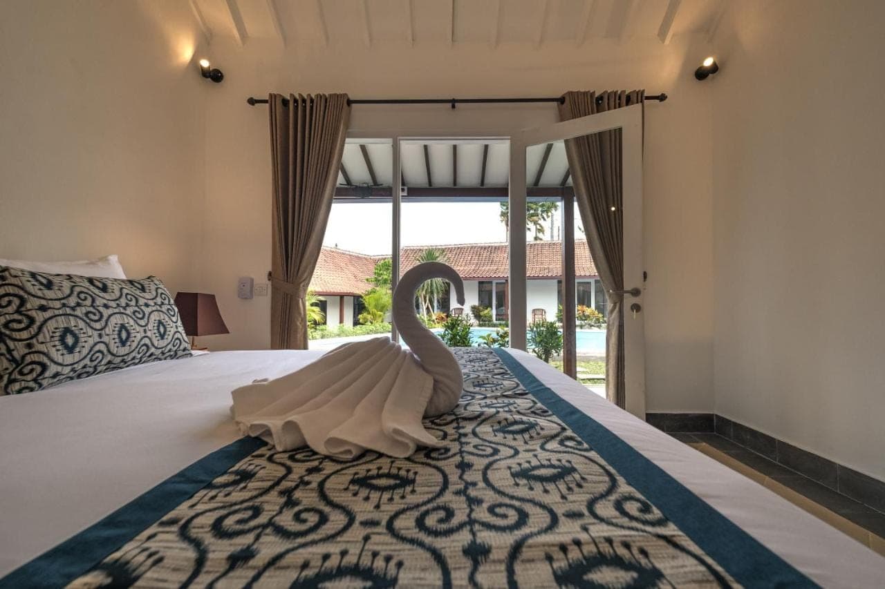 a swan decoration on a bed in a bedroom at Nami Surf Stay in Canggu