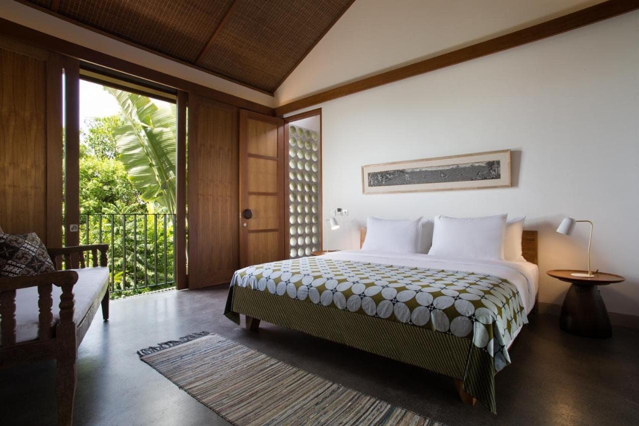 a bedroom with a bed and a large window at Atelier TE Designer Guesthouse in Sanur