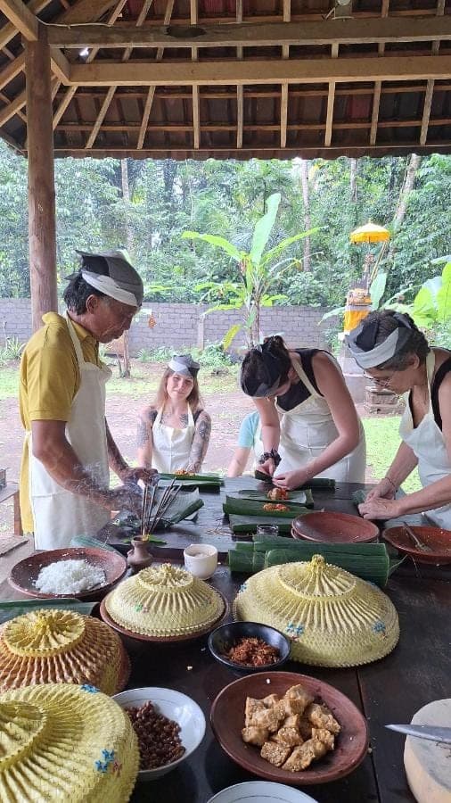 a group of people standing around a table with food at Pondok Masa Depan in Sidemen