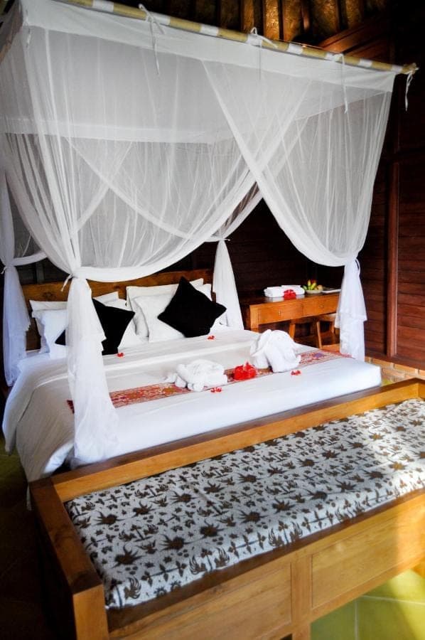 a bedroom with a large bed with a canopy at Pondok Masa Depan in Sidemen