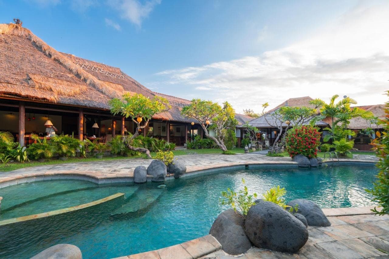 a swimming pool in front of a resort at Desamuda Village by Pertama Stay in Seminyak