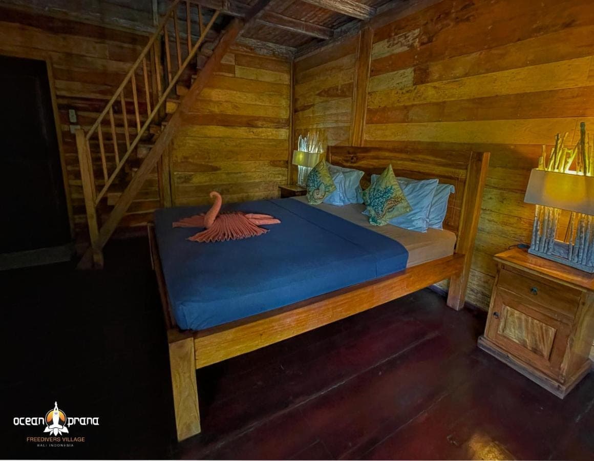 a bedroom with a bed with a swan on it at Ocean Prana Village in Amed