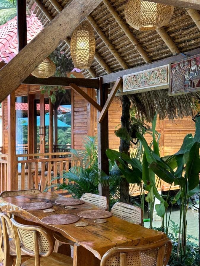 a wooden table and chairs on a patio at Uma Swari Villa Sidemen in Sidemen