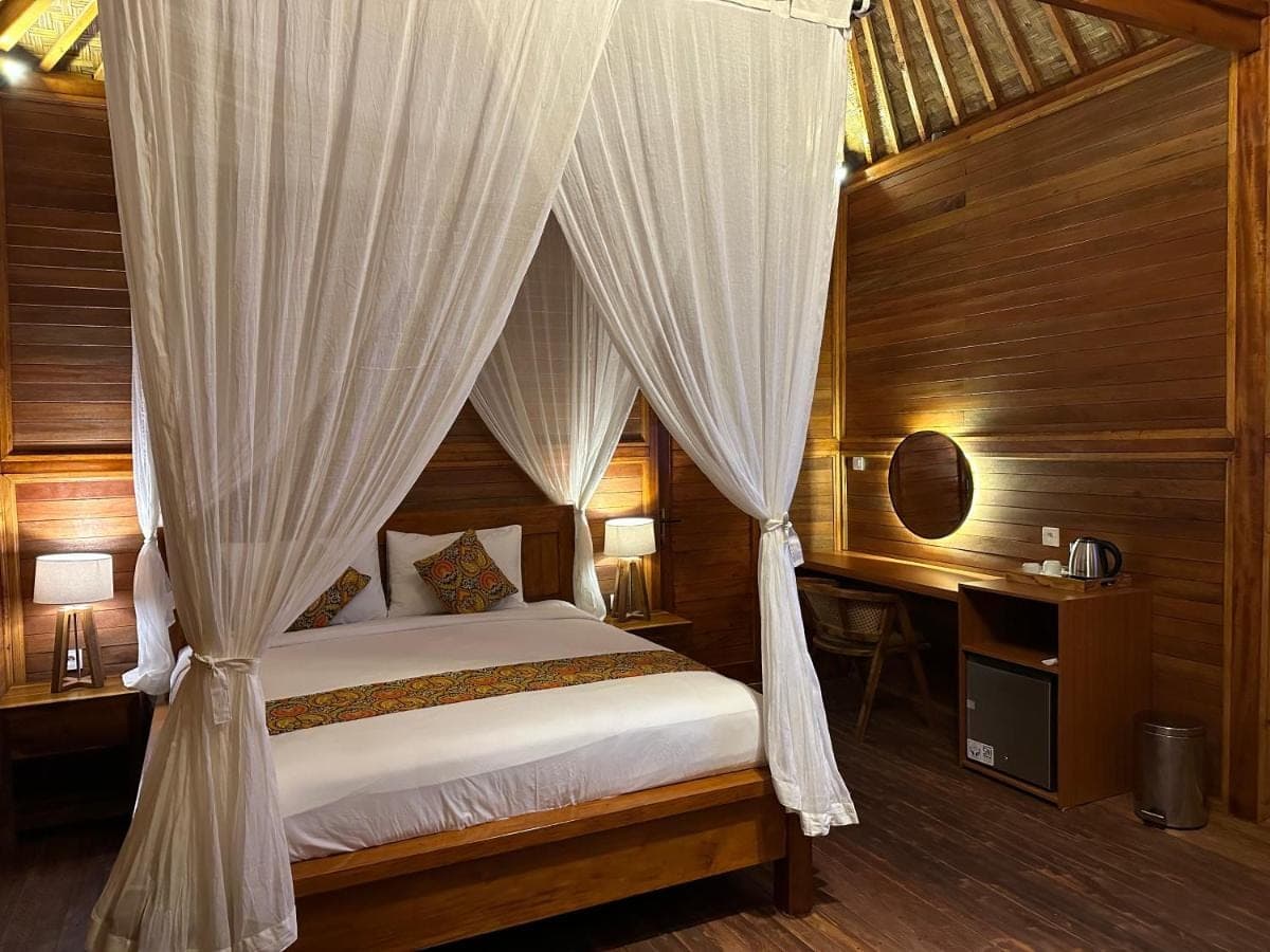 a bedroom with a canopy bed with curtains at Uma Swari Villa Sidemen in Sidemen