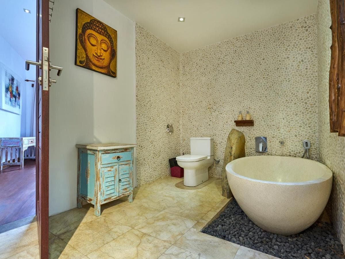 a bathroom with a bath tub and a toilet at Villa Mimpi Manis infinity pool&amp;180\u00b0Ocean view in Amed