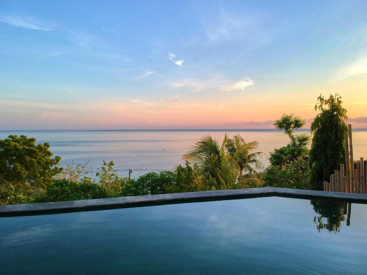 a swimming pool with a view of the ocean at Villa Mimpi Manis infinity pool&amp;180\u00b0Ocean view in Amed