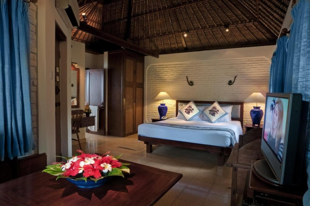 a bedroom with a bed and a tv in a room at Poppies Bali in Kuta