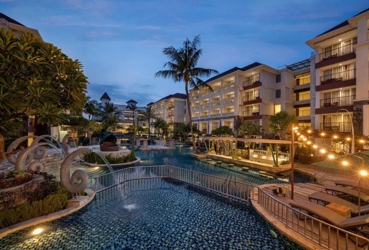 a swimming pool at a resort at night at Sanur Resort Watujimbar in Sanur