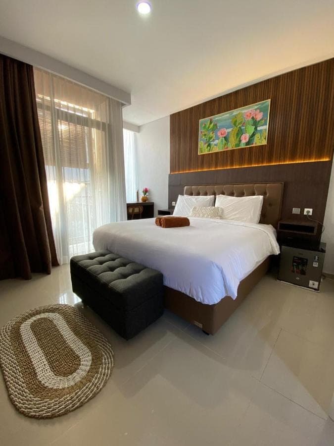 a large bedroom with a large bed and a couch at Queens Villa in Seminyak
