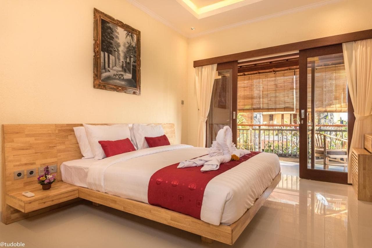 a bedroom with a large bed and a window at Bliss Ubud Abangan in Ubud