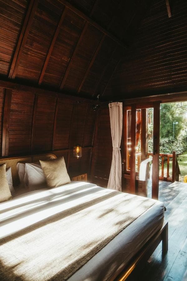 a large bed in a room with a window at Savanna Ubud in Ubud