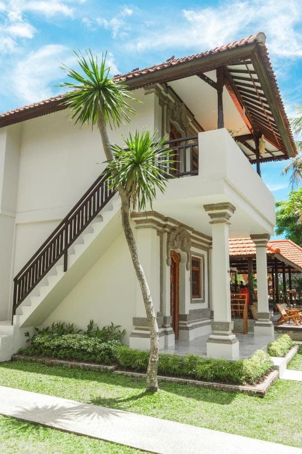 a house with two palm trees in front of it at Savanna Ubud in Ubud