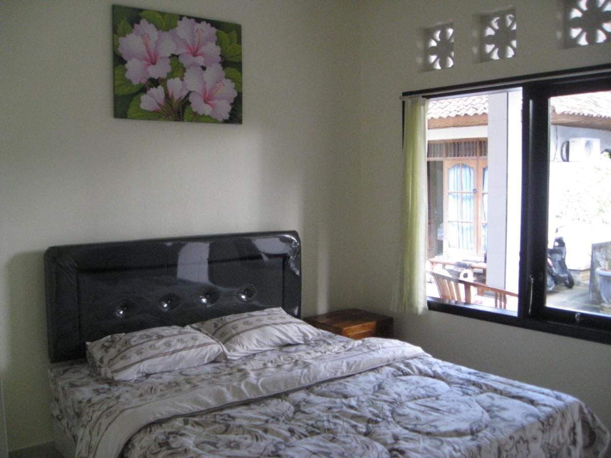 a bedroom with a bed and a window at Erwin's Guest Room in Sanur