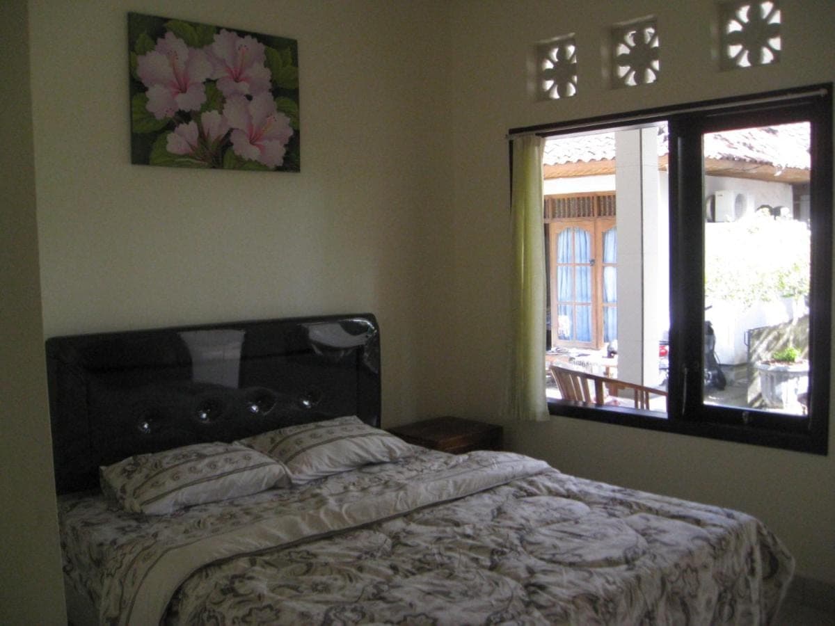 a bedroom with a bed and a window at Erwin's Guest Room in Sanur