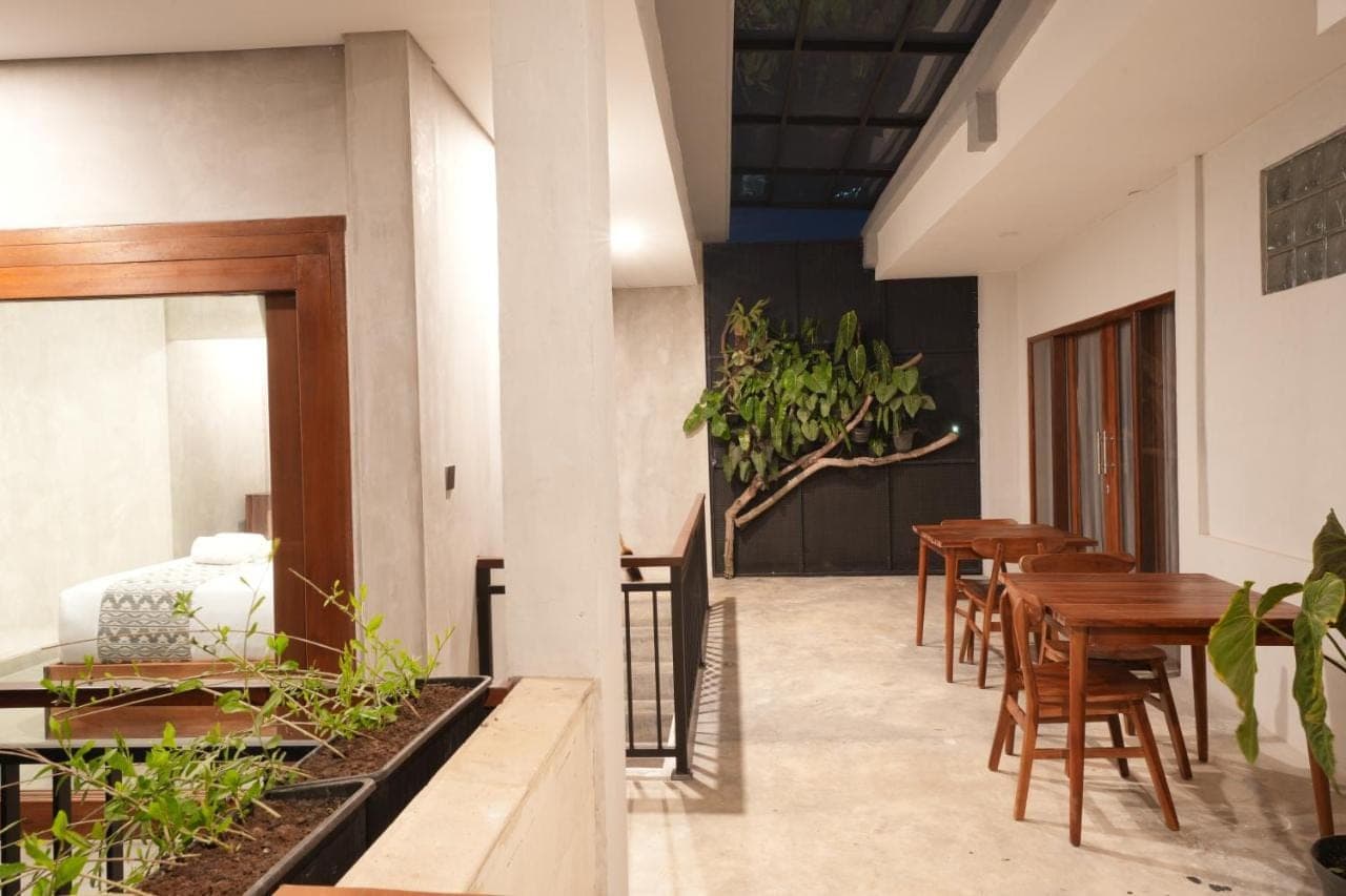 a dining room with wooden tables and chairs at Nuna House Ubud in Ubud