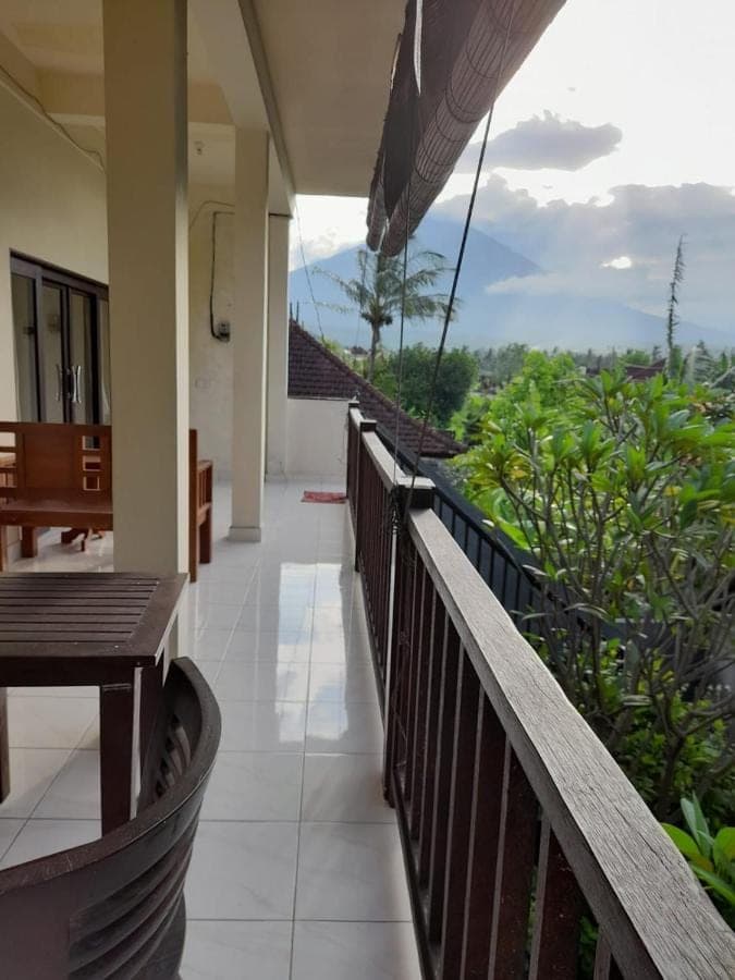 a balcony of a resort with a table and benches at Tanaya Homestay in Amed