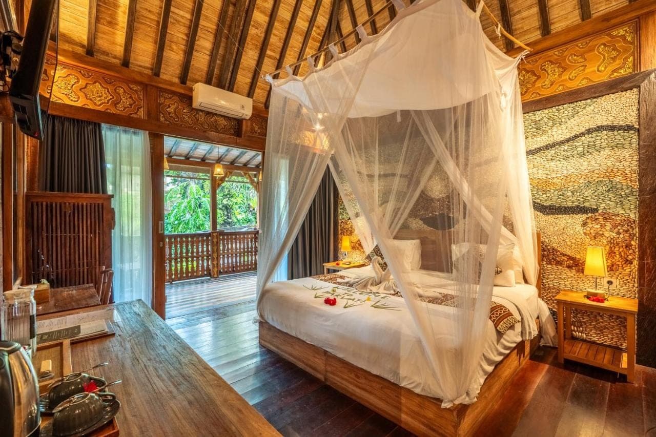 a bedroom with a bed with a mosquito net at Parvati Retreat Villas in Ubud
