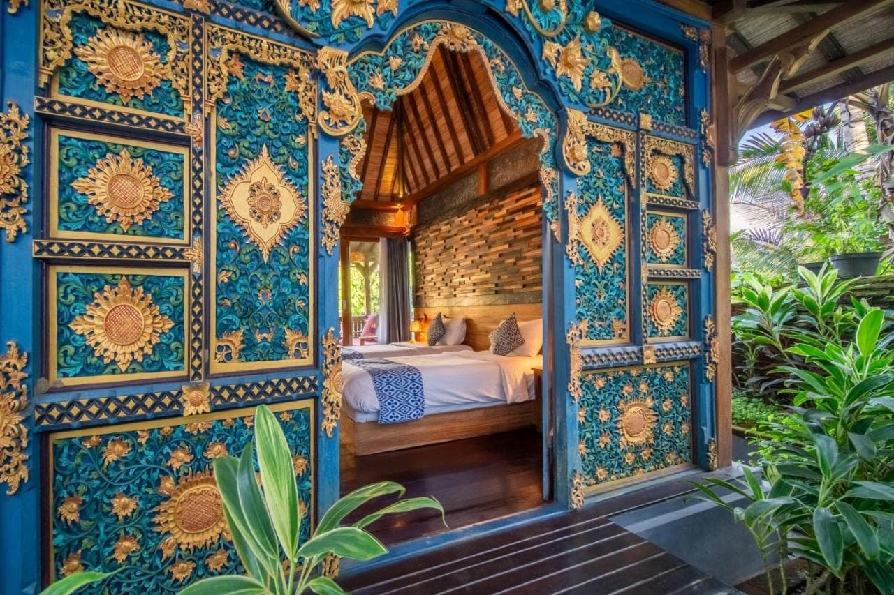 a bedroom with a bed in a room with blue and gold wallpaper at Parvati Retreat Villas in Ubud