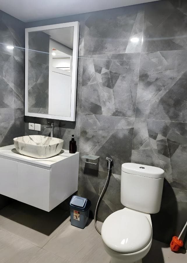 a bathroom with a white toilet and a sink at suka homestay in Sanur