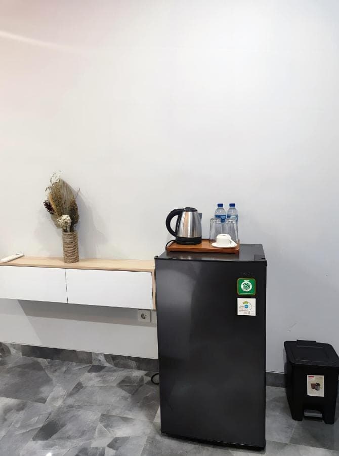 a black refrigerator in a kitchen with a counter at suka homestay in Sanur