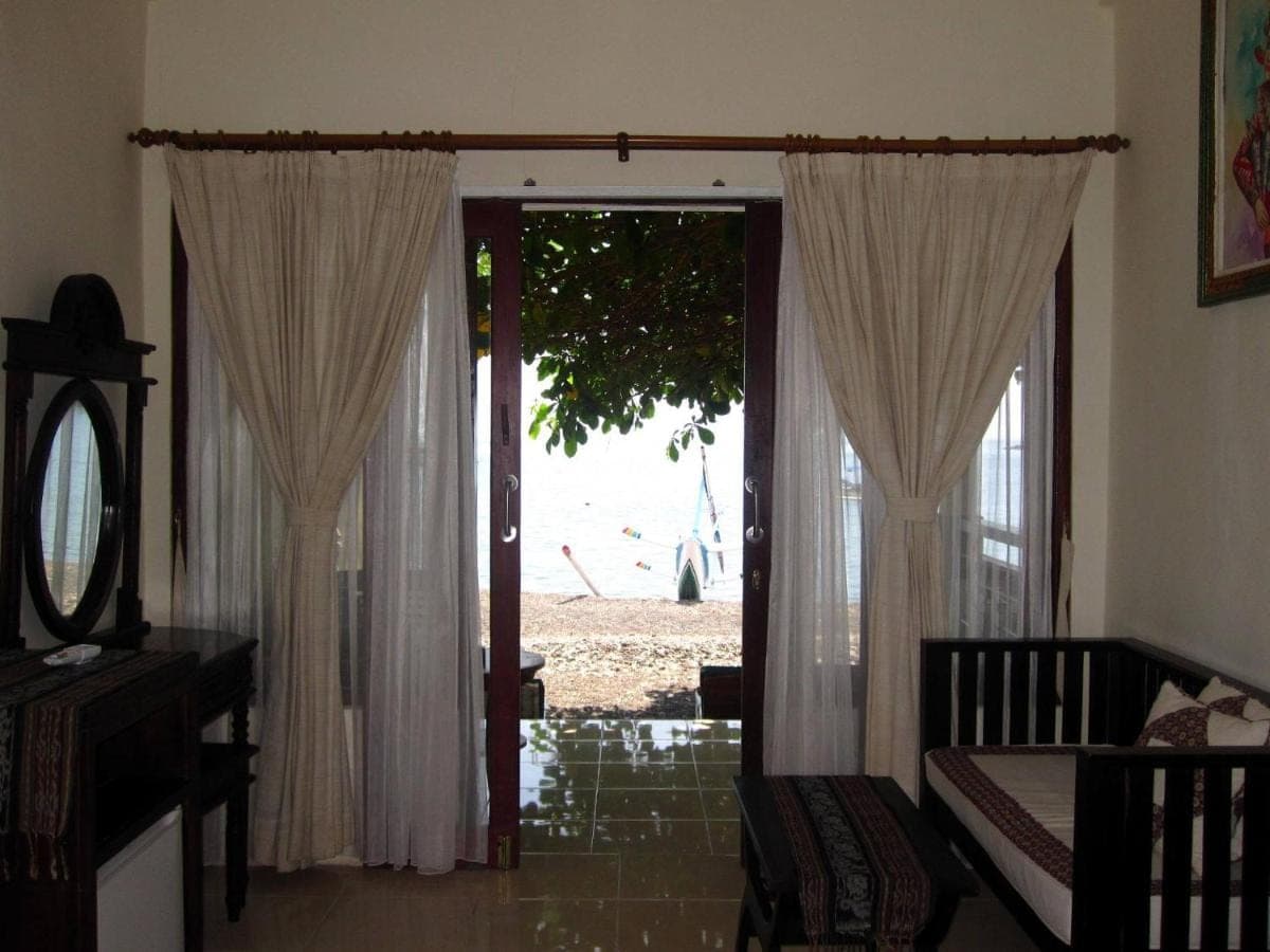 a living room with a door open to a patio at Galang Kangin Bungalows in Amed