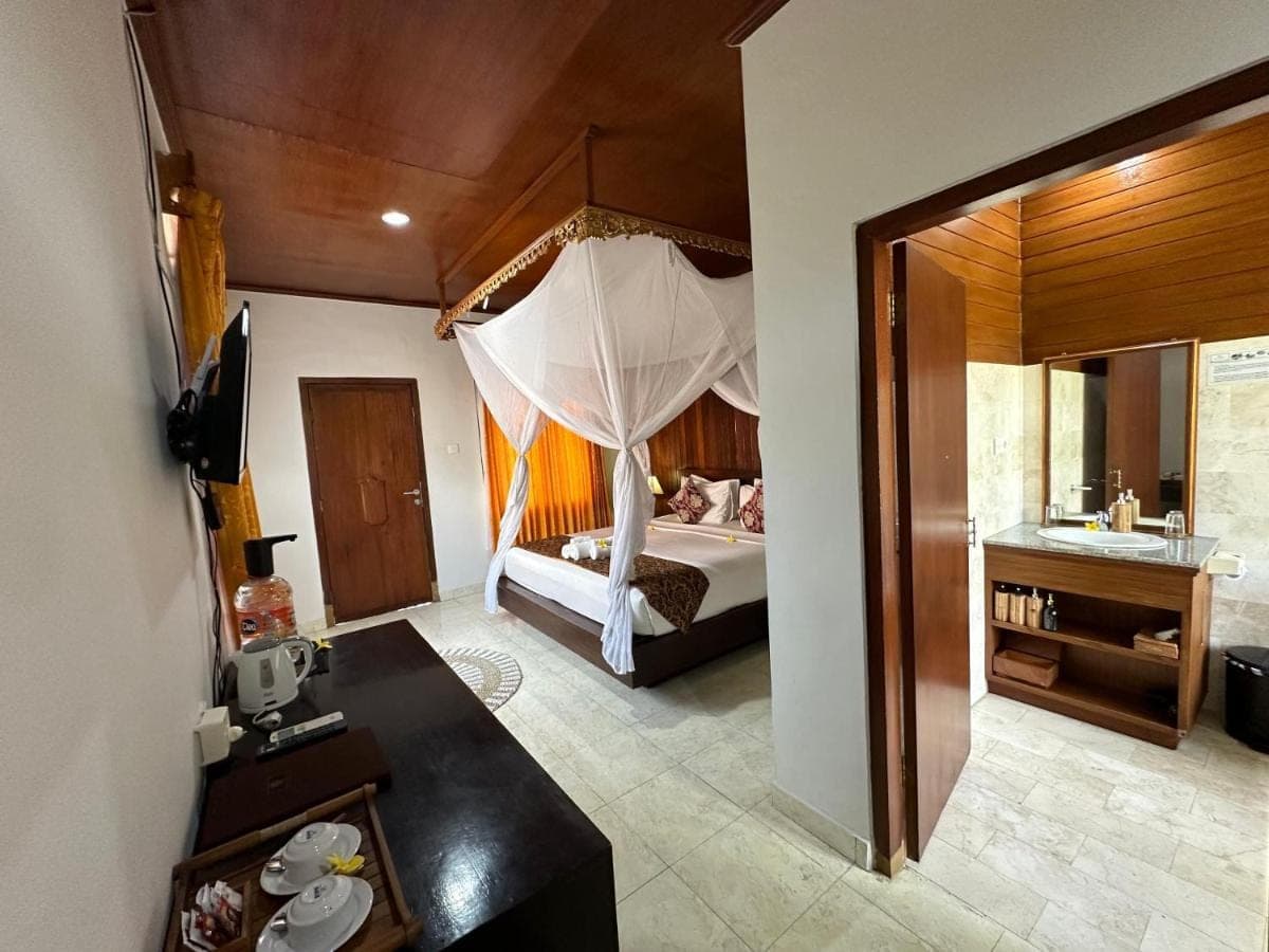 a bedroom with a bed with a canopy at Saren Indah Hotel in Ubud