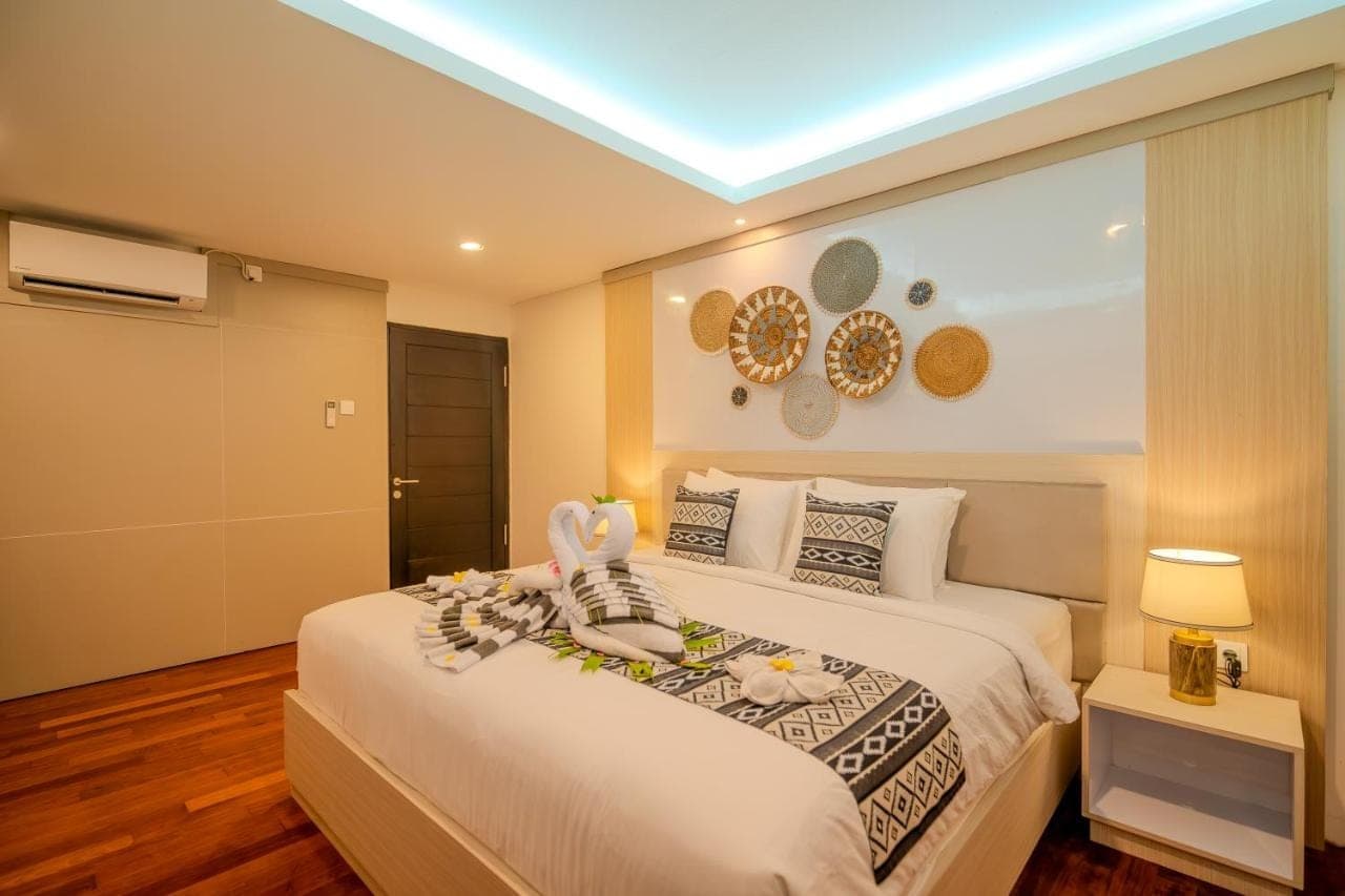 a bedroom with a bed with towels on it at Mamo Hotel Uluwatu in Uluwatu