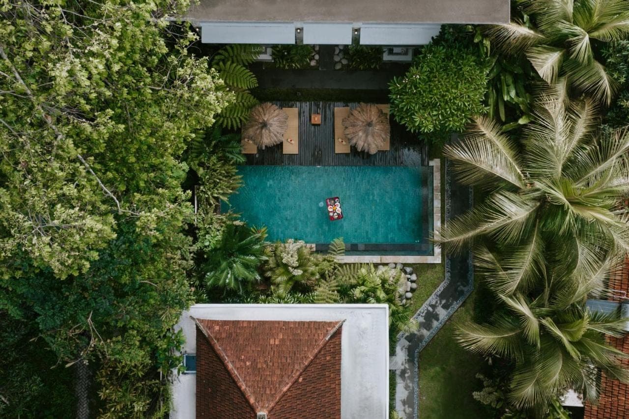 an aerial view of a resort with a swimming pool and palm trees at The Umari in Ubud