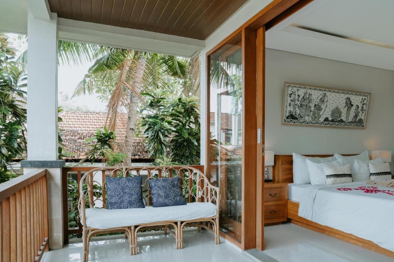 a bedroom with a bed and a balcony at The Umari in Ubud