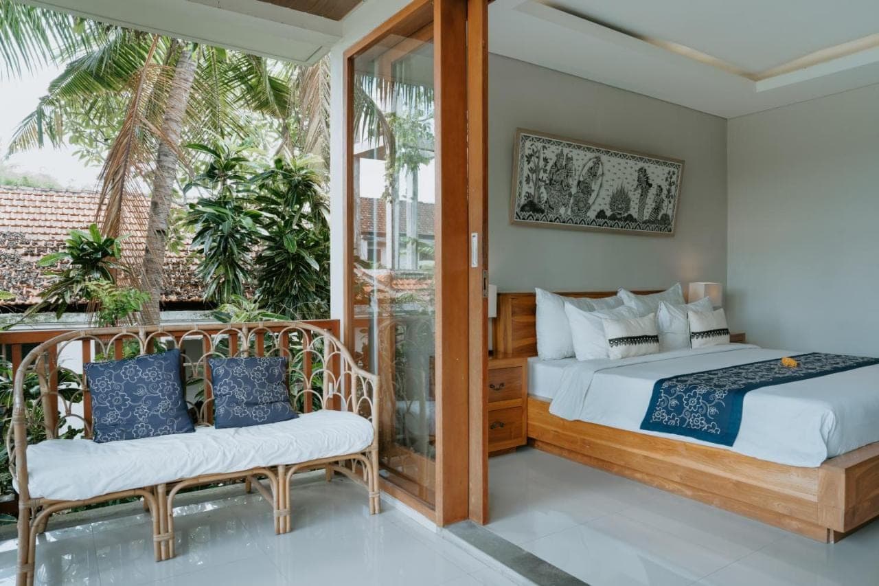 a bedroom with a bed and a balcony at The Umari in Ubud