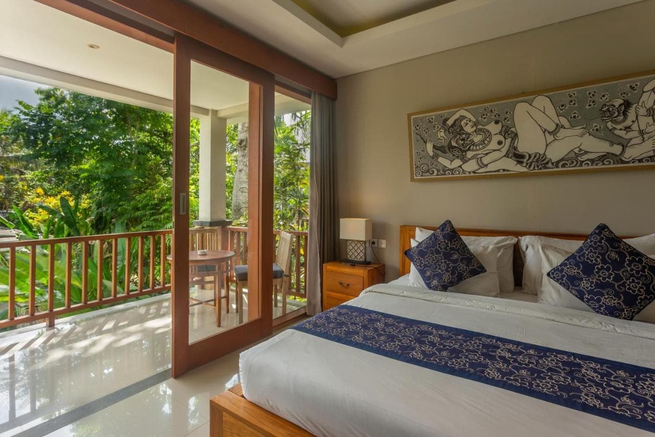 a bedroom with a bed and a balcony at The Umari in Ubud