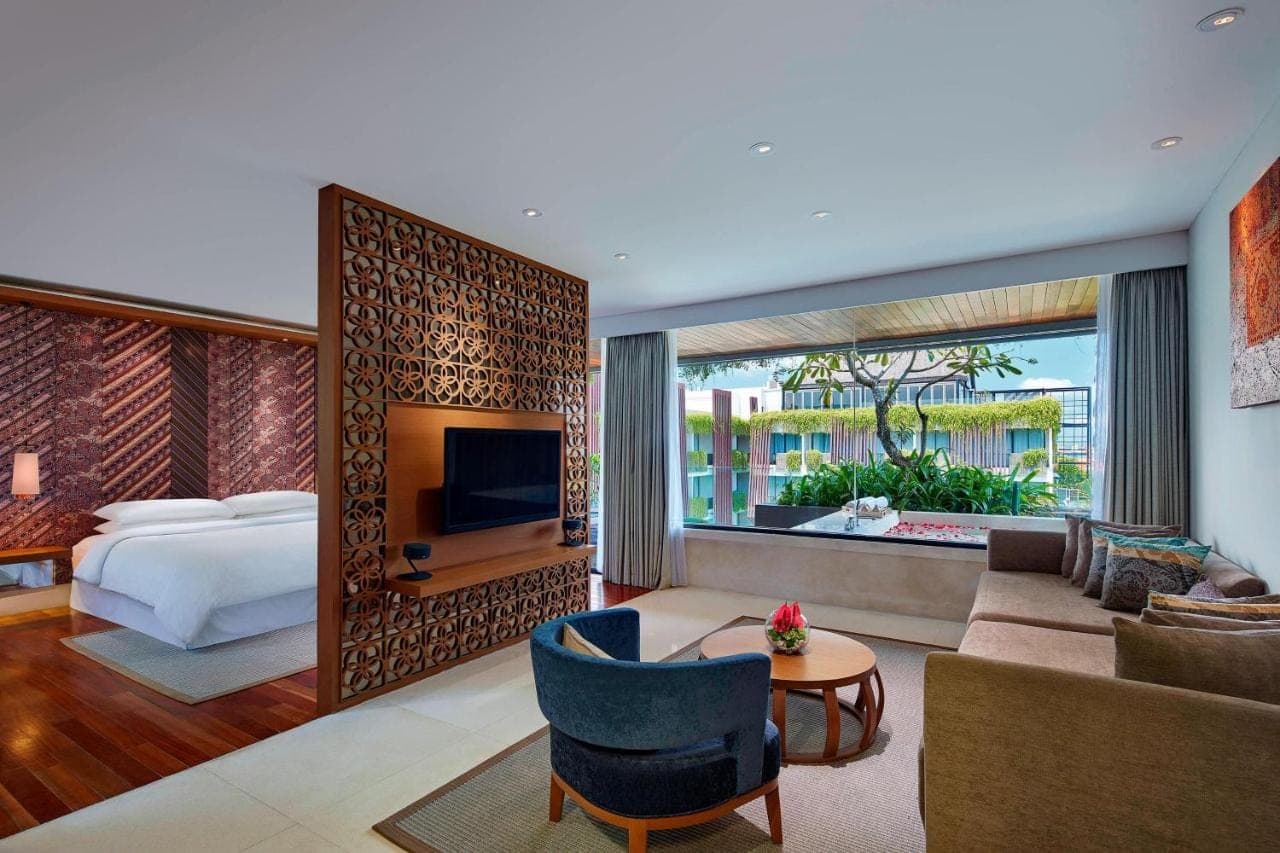 a hotel room with a bed and a living room at Four Points by Sheraton Bali, Seminyak in Seminyak
