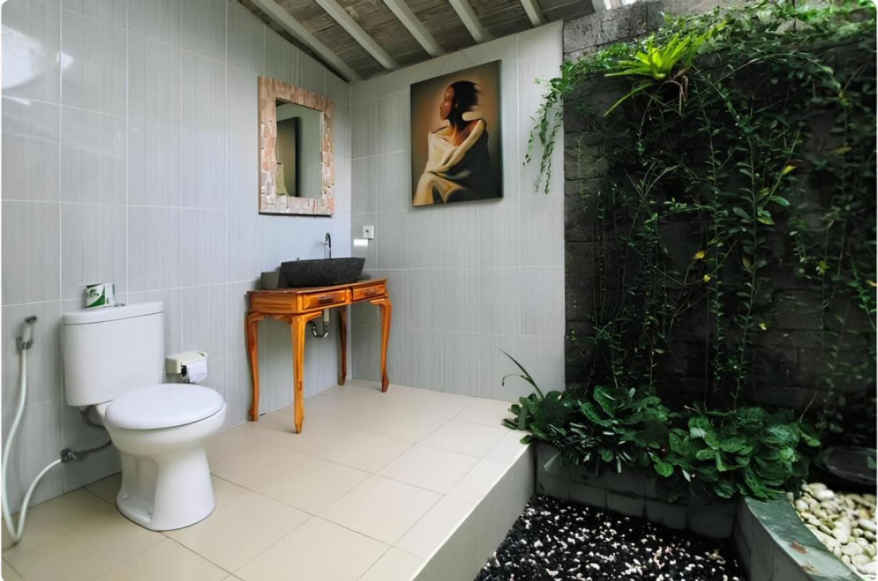 a bathroom with a toilet and a sink at Bale Bali Inn in Ubud
