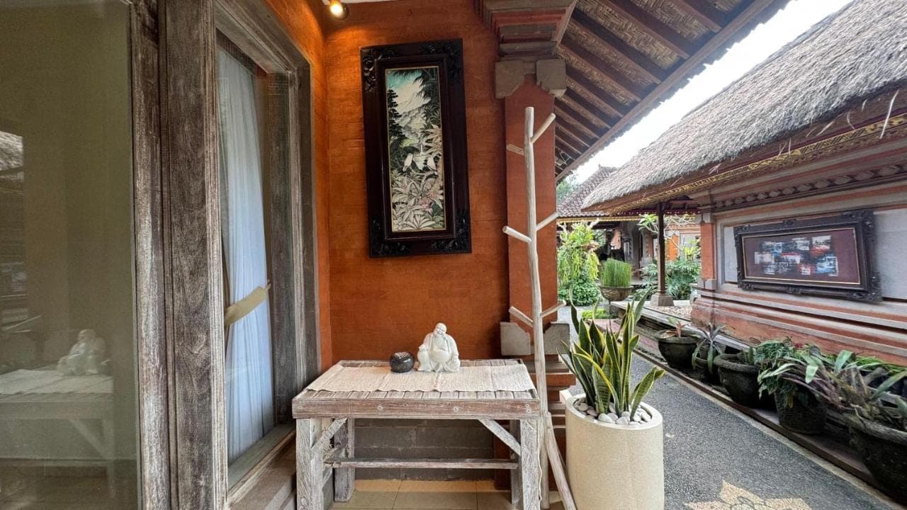 a porch of a house with a table and plants at Bale Bali Inn in Ubud