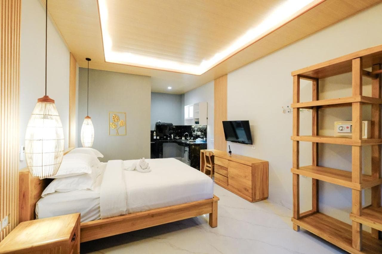 a bedroom with a white bed and a television at Kris Residence Sanur in Sanur