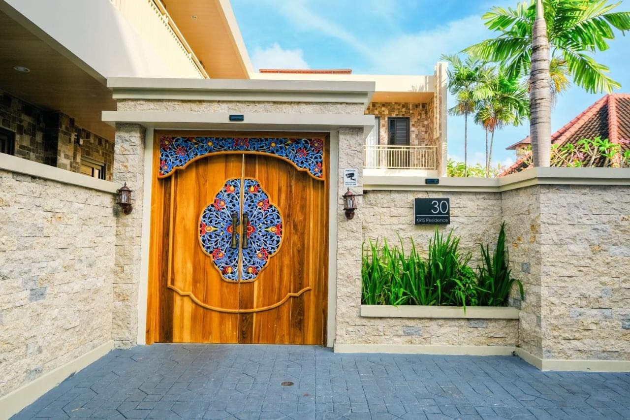 a wooden door with a mosaic design on it at Kris Residence Sanur in Sanur