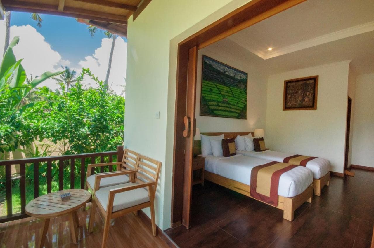 a bedroom with a bed and a balcony at Uma Dawa Resort and Spa in Ubud