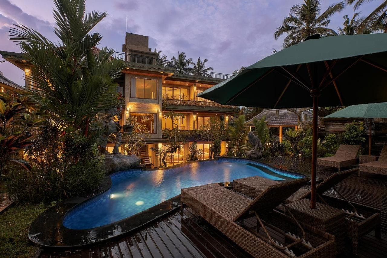 a house with a swimming pool in front of a house at Gynandha Ubud Cottage in Ubud