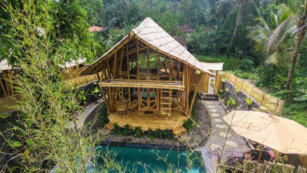 a wooden house with a pool in front of it at Bamboo House - Ecobreeze in Sidemen
