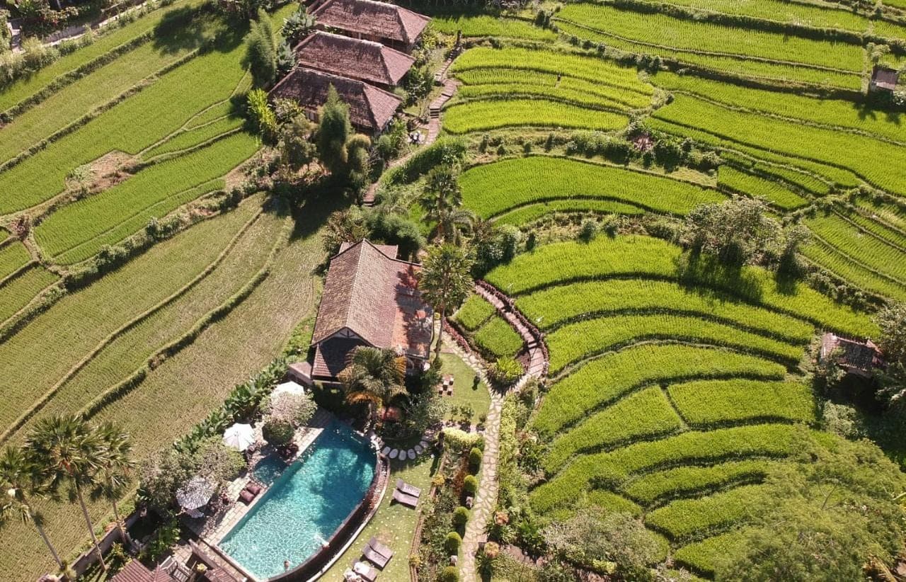 an aerial view of a resort with a pool in a field at Sawah Indah Villa in Sidemen