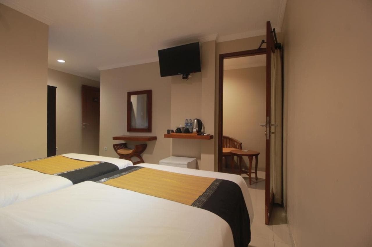 a hotel room with a bed and a mirror at Nesa Sanur Bali in Sanur