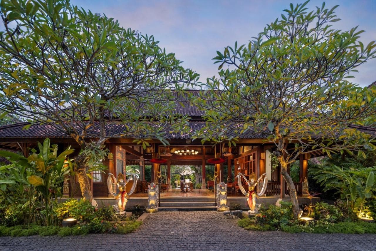 a resort with a pathway leading to a building with trees at The Alantara Sanur in Sanur