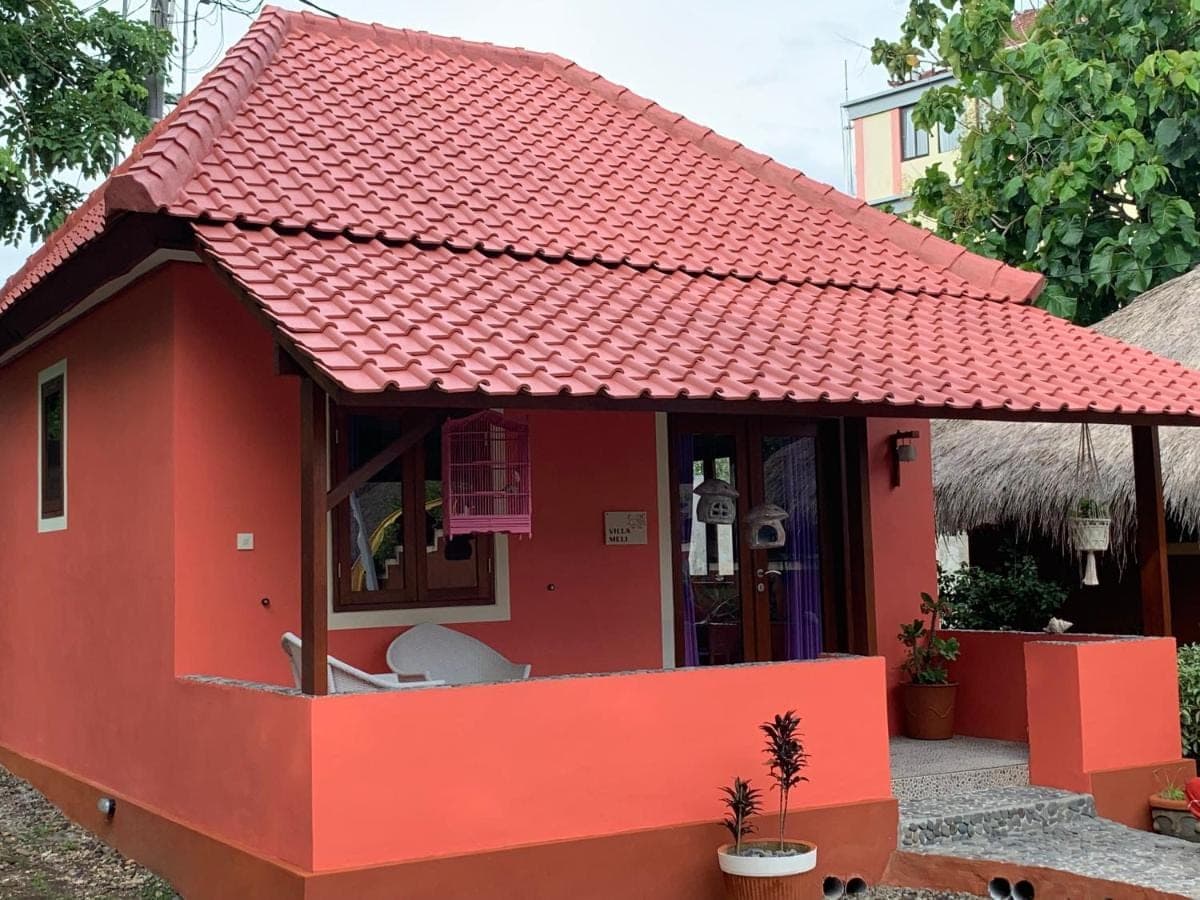 a small red house with a red roof at Villa Anjing in Nusa Dua